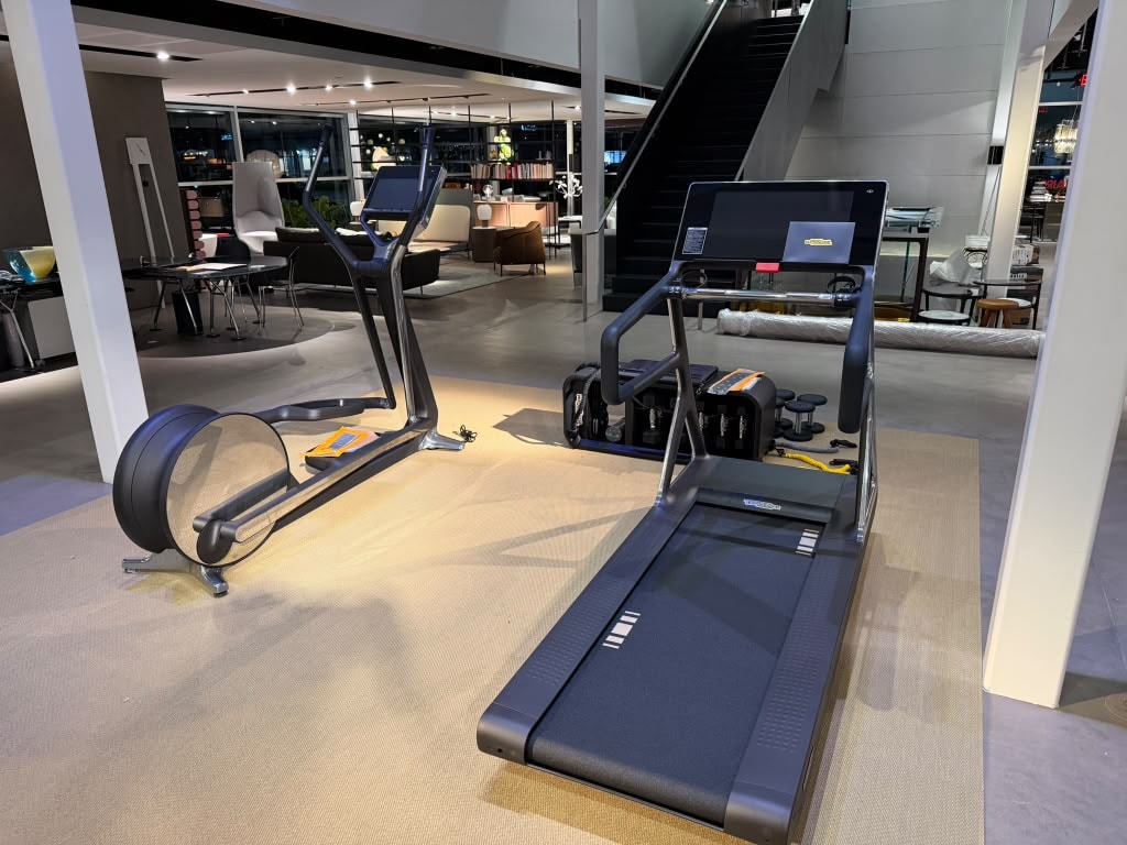 TechnoGym treadmill and elliptical in modern showroom at night