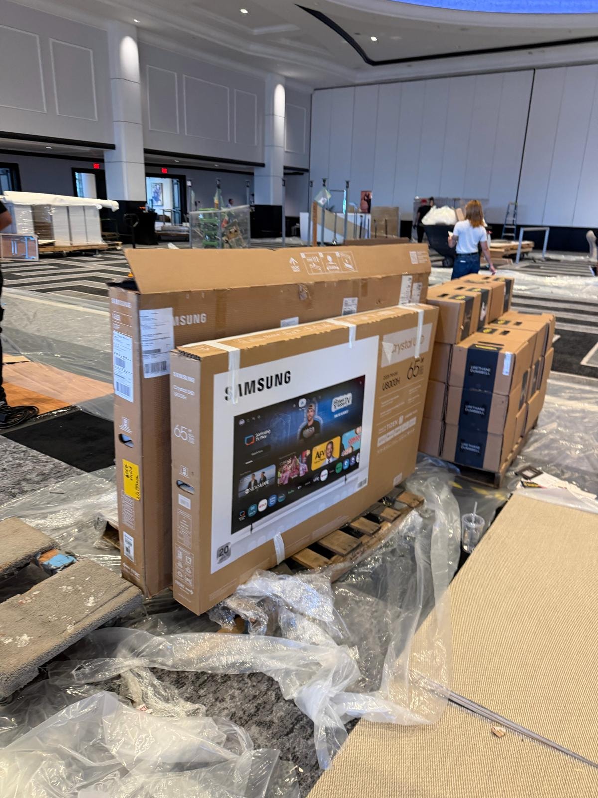 Samsung TVs and display equipment staged on pallets for trade show setup