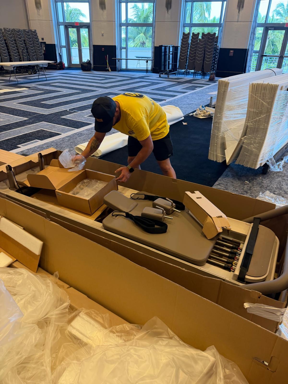 StrongArm crew member unpacking pilates reformer at trade show venue